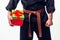 Close up Young male with orange belt karate fighter training with gift box