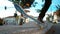 CLOSE UP Young male skateboarder tail grinds a concrete ledge in urban skatepark