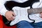 Close up of a Young man adjusting electric guitar volume. Music, instrument education, entertainment