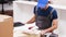 Close up of young man in coverall using laptop to assembly furniture