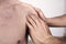 Close-up of a young man having chiropractic shoulder adjustment. Physiotherapy, sports injury rehabilitation. Osteopathy,
