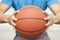 Close up of young man, midsection, holding a basketball