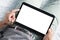 Close up of a young man raising the left index finger over the white screen of a digital tablet. Person starts working on tablet