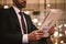 Close-up of young man reading newspaper while sitting at hotel restaurant