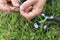 Close-up of a young man`s hand puts a worm on a fishing hook.