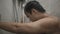 Close-up of a young man taking a shower in the bathroom with sad expression. Health care concept.