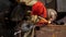 Close-up of a young manual worker using a metal grinder in a factory. Metal work