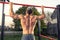 Close up of young muscular mans torso while he is doing pull ups taken from the back, close up of back muscles