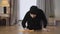 Close-up of young Muslim lady in hijab cleaning the floor with yellow rag. Diligent eastern housewife blowing at floor