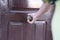 Close-up young person handle old door knob, Woman arm opening a rural hotel. Unlock retro doorway entry. Girl realtor entering