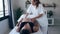 Close up of young physiotherapist woman massaging tummy on pregnant woman on a stretcher at home.