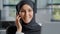 Close-up young smiling arab woman secretary in hijab talking on phone in office female sales agent consult client remote
