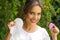 Close up of a young smiling beautiful woman holding a menstrual cup in one hand and a hygienic towel in her other hand