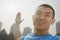 Close up of young, smiling, muscular man stretching, hands outstretched in Beijing, China