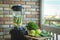 Close up of young woman with blender and green vegetables making detox shake or smoothie at home