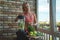 Close up of young woman with blender and green vegetables making detox shake or smoothie at home