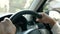 Close up of Young woman driving a car, hand put on the black steering wheel and looking forward with determination