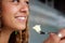 Close up young woman face eating cake with fork.