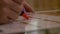 Close-up of young woman hand marking and counting the prevention birth treatment dates on calendar using red marker