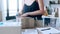 Close-up of young woman hands holding packing machine and sealing cardboard boxes with duct tape to delivery products in