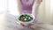 Close up of young woman hands showing salad bowl
