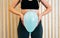 Close up of a young woman holding a balloon to explain the diaphragm zones, core and pelvic floor. Pelvic floor exercises