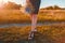 Close-up of young woman holding flowers outdoors. Close-up of shoes. Body care. Healthy legs in summer