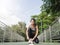 Close up of young woman lace up her shoe ready to workout on exercising in the park with warm light sunshine in morning.