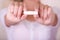 Close up of a young woman pointing in front of her a menstruation cotton tampon in a blurred background