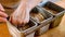 Close-up of young woman pressing dough in baking form for bread