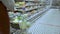 Close-up of a young woman's hands moving a grocery cart through the aisles of a supermarket, the concept of sale and