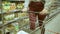 Close-up of a young woman's hands moving a grocery cart through the aisles of a supermarket, the concept of sale and