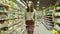 Close-up of a young woman's hands moving a grocery cart through the aisles of a supermarket, the concept of sale and