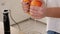 Close-up of a young woman squeezing the juice from an orange into a blender.