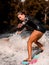 Close-up of young woman in swimsuit riding wave on surf style wakeboard