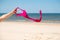 Close up of young woman taking off her bra at nude beach. Concept of sunbathing naked on the sandy ocean beach. Naturalist