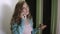 Close-up of a young woman talking on the phone at home holding the keys to the apartment