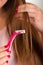 Close up of a young woman using a shaver on her hair, bath background