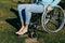 Close up of a young woman in a wheelchair while walking in a park on a sunny day. Recovery and healthcare concepts