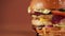 Close-up of a yummy grilled chicken burger rotation on a brown background.