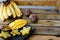 Close up yummy mango and carambola on plate near bananas on wooden table.