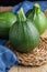 Close-up of zucchini with blue checkered cloth, on wooden table and black background