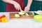 Close up of zucchini cut man hands on wooden cutting board with white knife. Vegetables and Zucchini slice for steaming