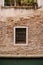 Close-ups of building facades in Venice, Italy. Brick stone wall with window, completely closed by metal forged grille