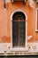 Close-ups of building facades in Venice, Italy. An old black, scratched door, in an arched doorway, with a rusty forged