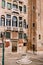 Close-ups of building facades in Venice, Italy. An old street well in the square in front of a brick house. There are