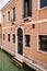 Close-ups of building facades in Venice, Italy. A two-story building near the water in a narrow Venetian canal. On the