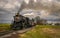 Close View of An Approaching Steam Passenger Train Traveling Thru Farmlands