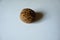 Close view of brown rounded wrinkly fruit of Persian walnut