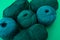 Close view of dark green balls of yarn with different types of t